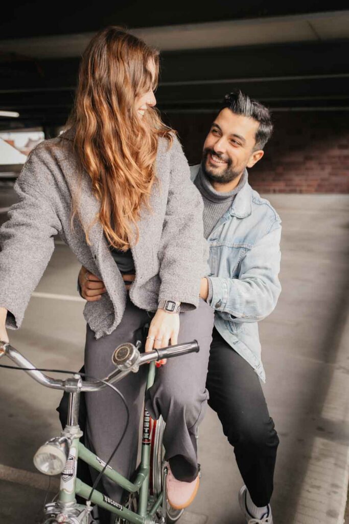 Paarshooting Dortmund auf dem Parkdeck Paar sitzt auf dem Fahrrad und beide schauen sich an