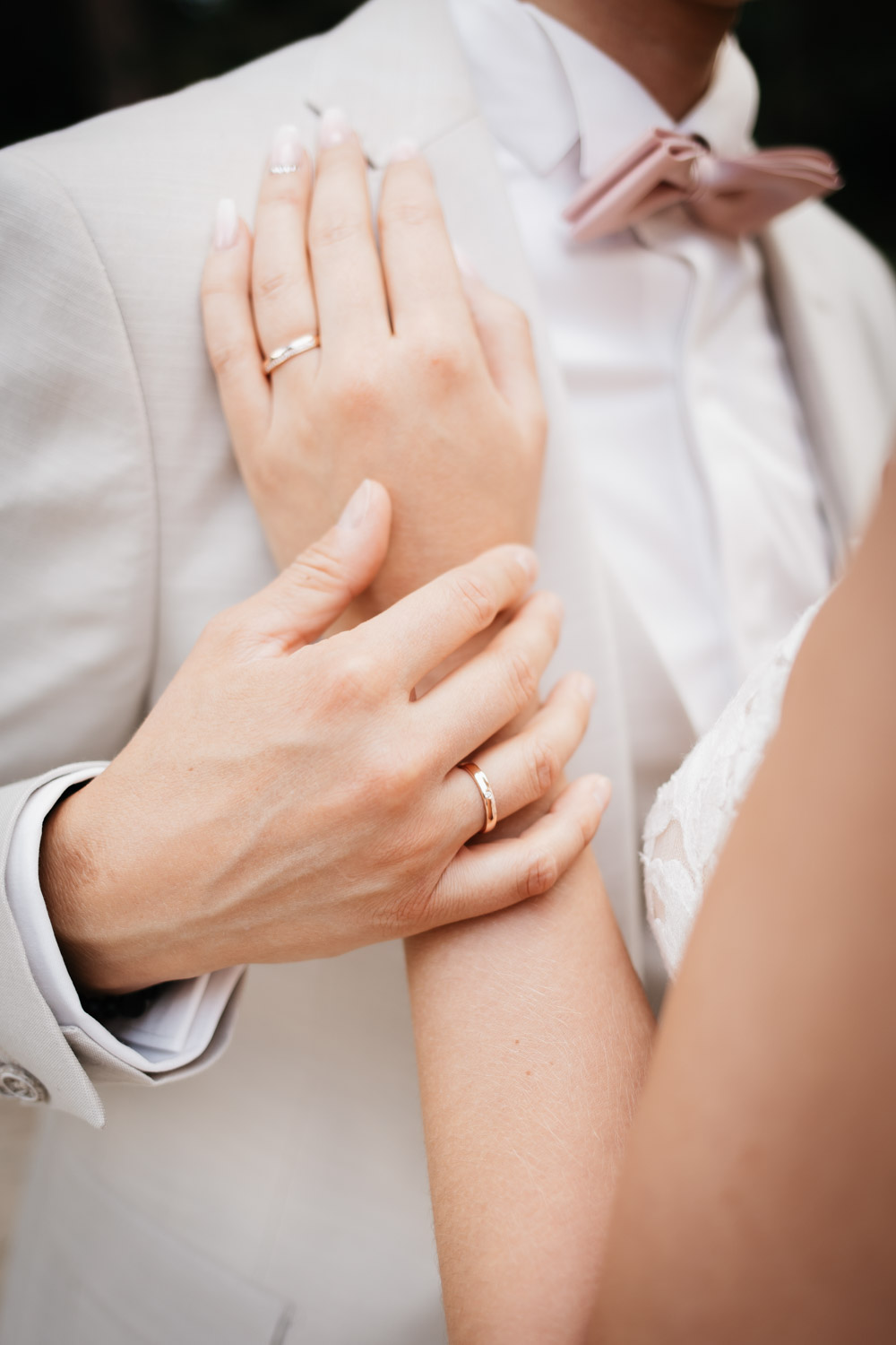 Hochzeitspaar steht zueinande, eine Hand liegt auf der Brust, Hände berühren sich