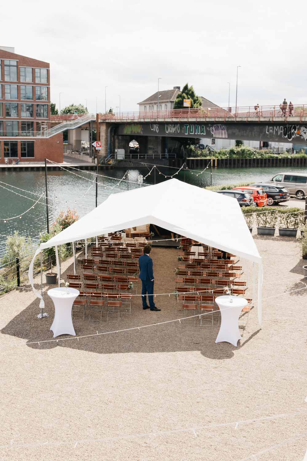 Tyde Dortmund Außenbereich Zelt mit aufgereihten Stühlen vor der Hochzeit