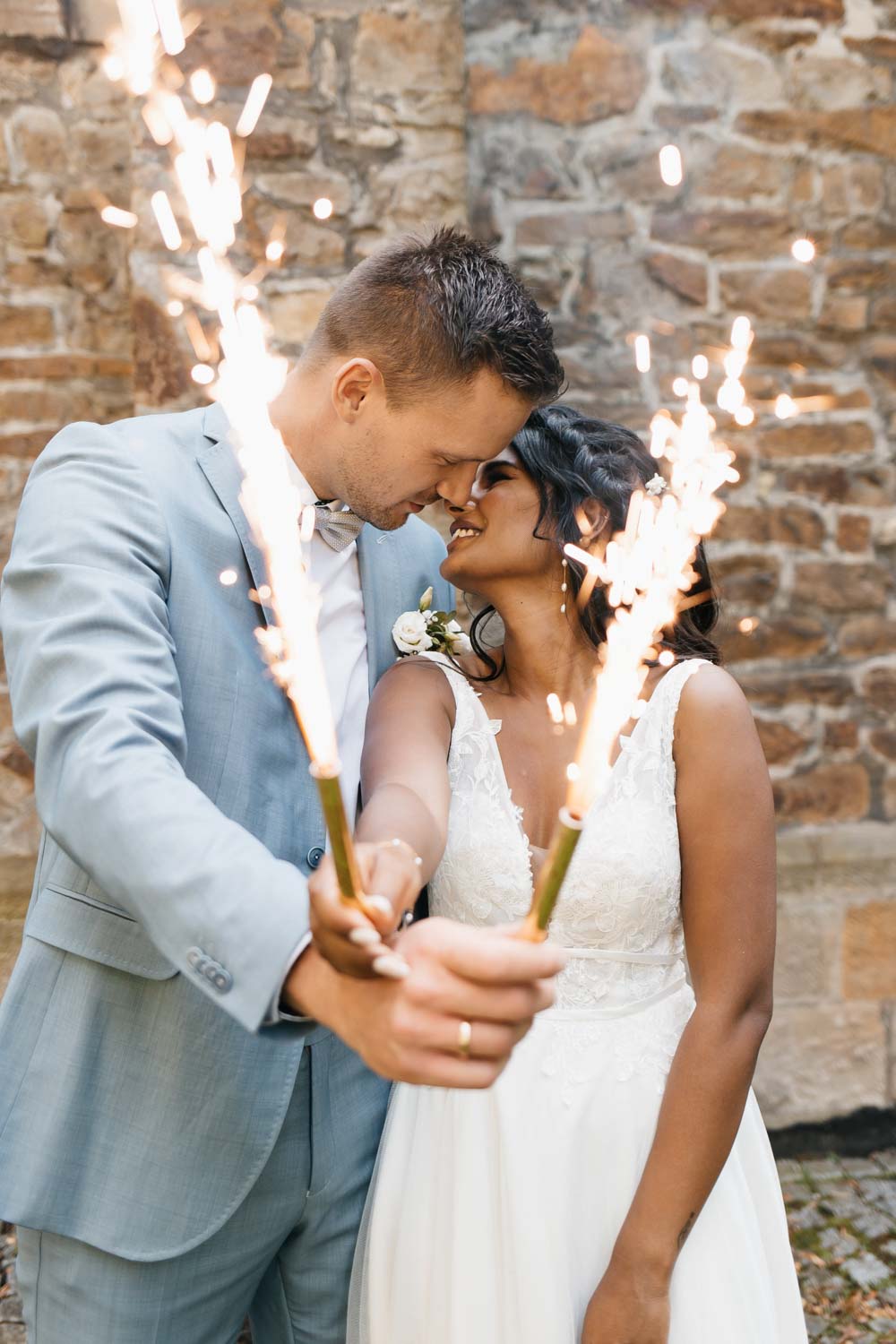 Hochzeitspaar küsst sich und hält die Eisfontäne Hochzeit Schloss Heeren in Bergkamen