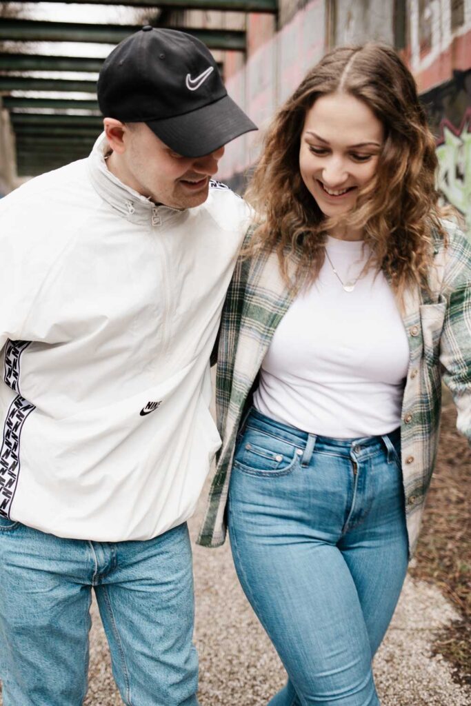 Paarshooting Phoenix West Dortmund Paar läuft nah an der Kamera vorbei und lächelt auf den Boden