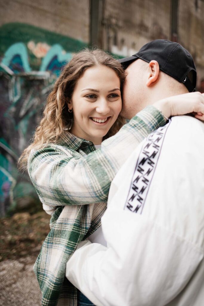 Paarshooting Phoenix West in Dortmund, Freund flüstert seiner Freundin etwas ins Ohr, sie lacht dabei